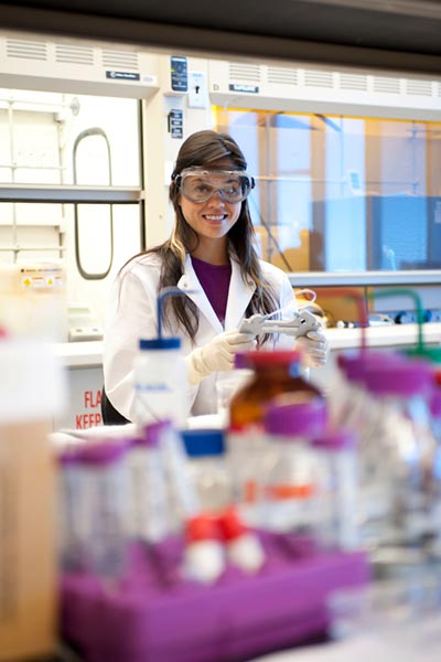 UTSA student smiles as she conducts research in a lab.